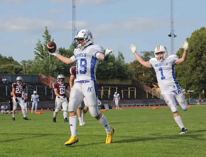 Dalecarlia Rebels players celebrating a touchdown on the field